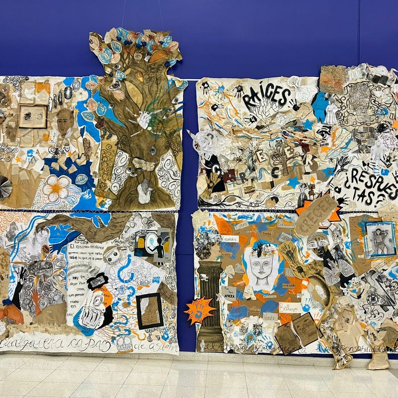 Gran mural de collage de estudiantes con la palabra «Raíces», sobre una pared azul
