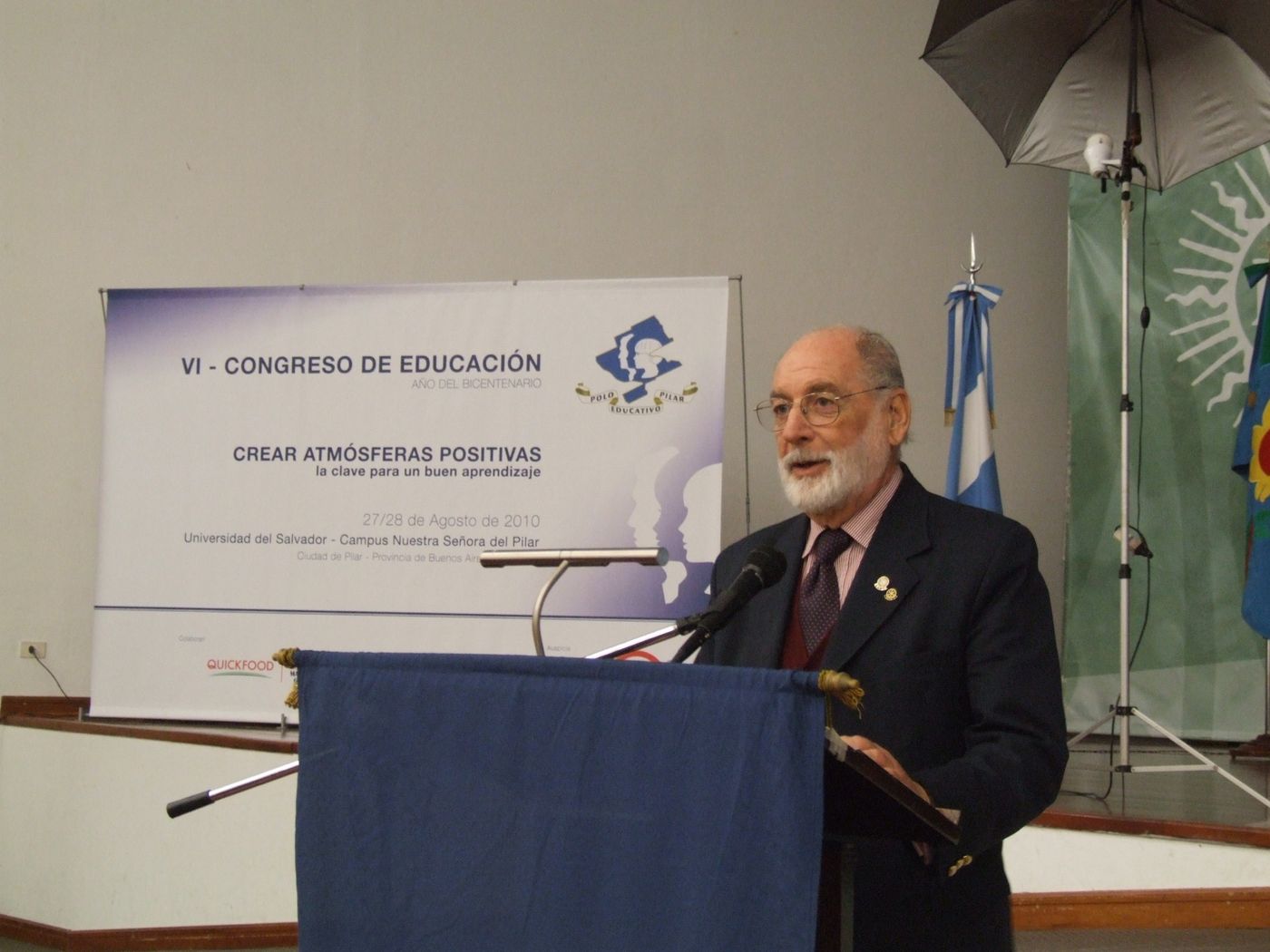Un orador habla desde el atril del Congreso de Educación de 2010, junto a la bandera argentina