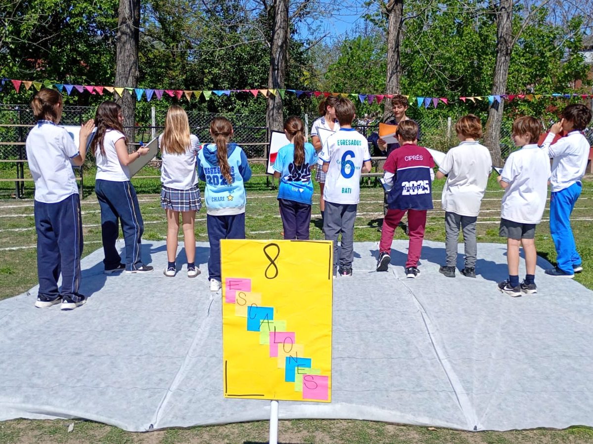 Estudiantes en uno de los stands de la Kermese, al aire libre y bajo guirnaldas de banderines