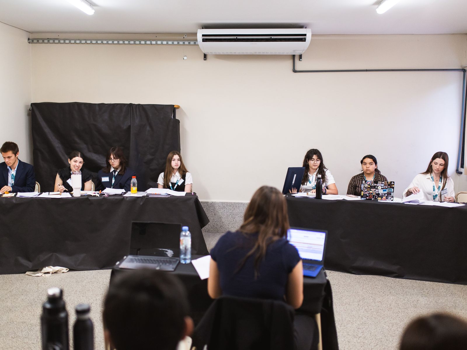 Estudiantes en una sesión de debate del PEP MUN, sentados en las mesas del comité
